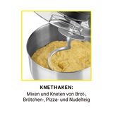 Knethaken einer Küchenmaschine in einer Schüssel mit Teig, seitliche Perspektive