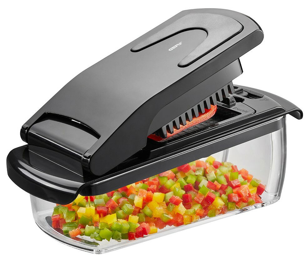 Schwarzer Würfel- und Stifteschneider Treppo mit transparentem Auffangbehälter, gefüllt mit bunten Gemüsewürfeln. Seitliche Perspektive.