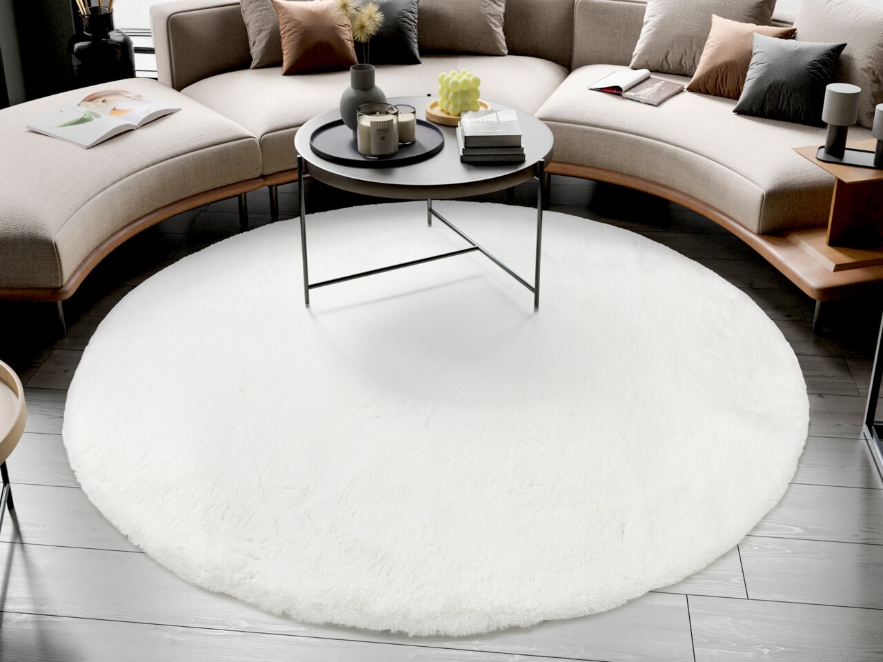 Runder weißer Fellteppich in einem modernen Wohnzimmer, umgeben von einem geschwungenen Sofa und einem runden Couchtisch. Perspektive von oben.