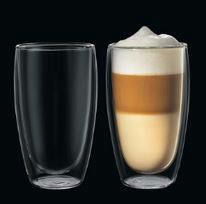 Zwei Latte Macchiato Gläser, eines leer und eines gefüllt, aus seitlicher Perspektive