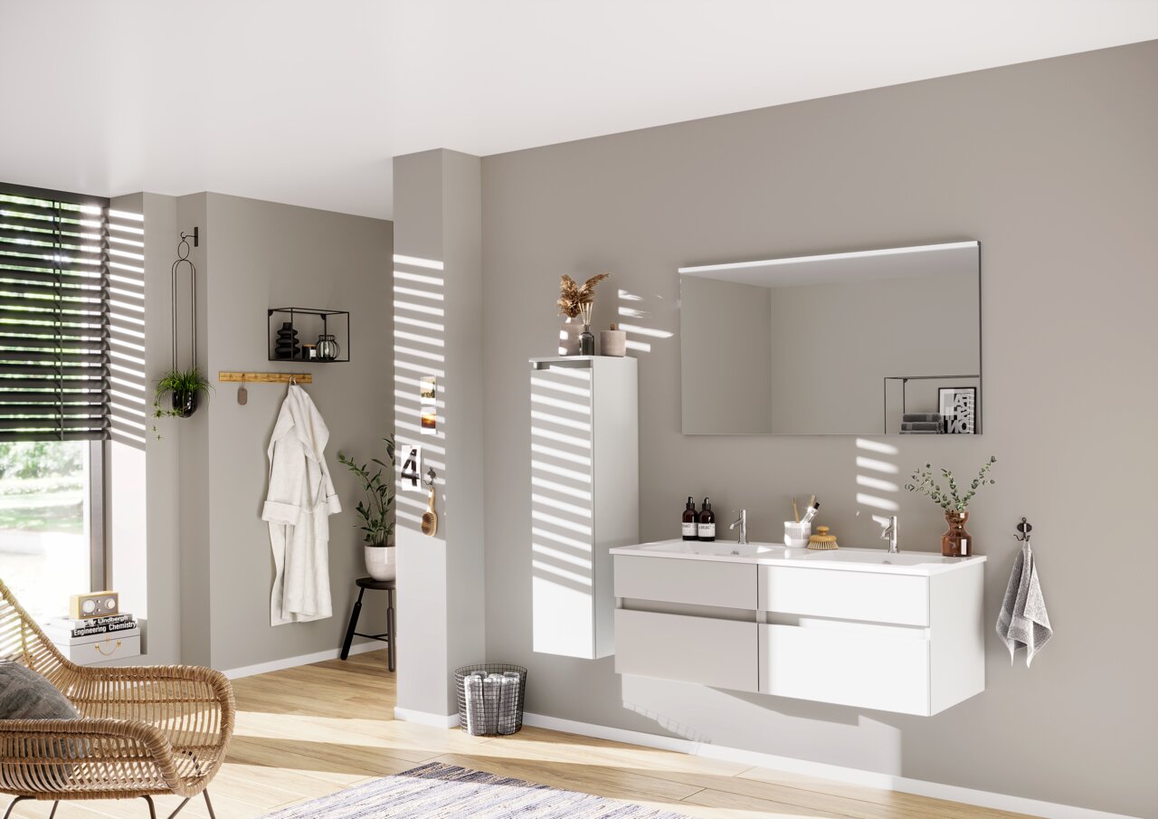 Moderne badkamercombinatie uit de NEXT4YOU-serie van Puris, bestaande uit een grote spiegel, een dubbele wastafel met twee lades en een hoge, smalle kast. De afbeelding toont de badkamer van opzij, met natuurlijk licht dat door