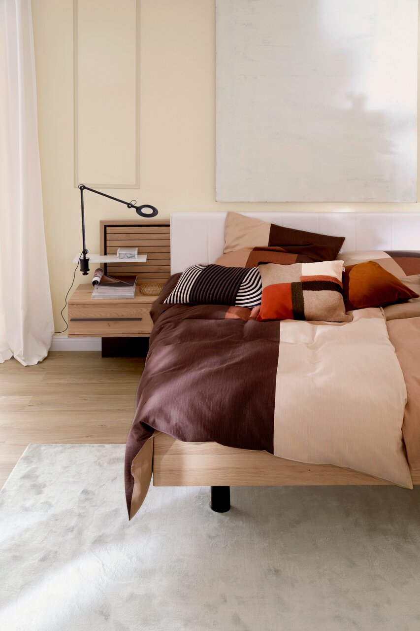 Satin-Bettwäsche 135x200 cm in warmen Erdtönen auf einem modernen Bett, seitliche Perspektive