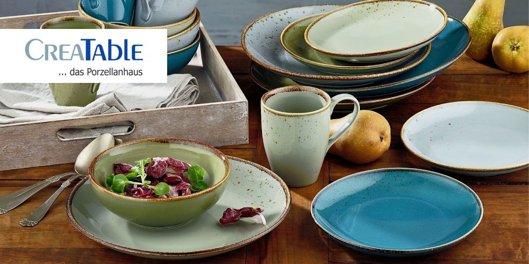 Een stijlvol gedekte tafel met rustiek servies in blauw- en groentinten van het merk Creatable.