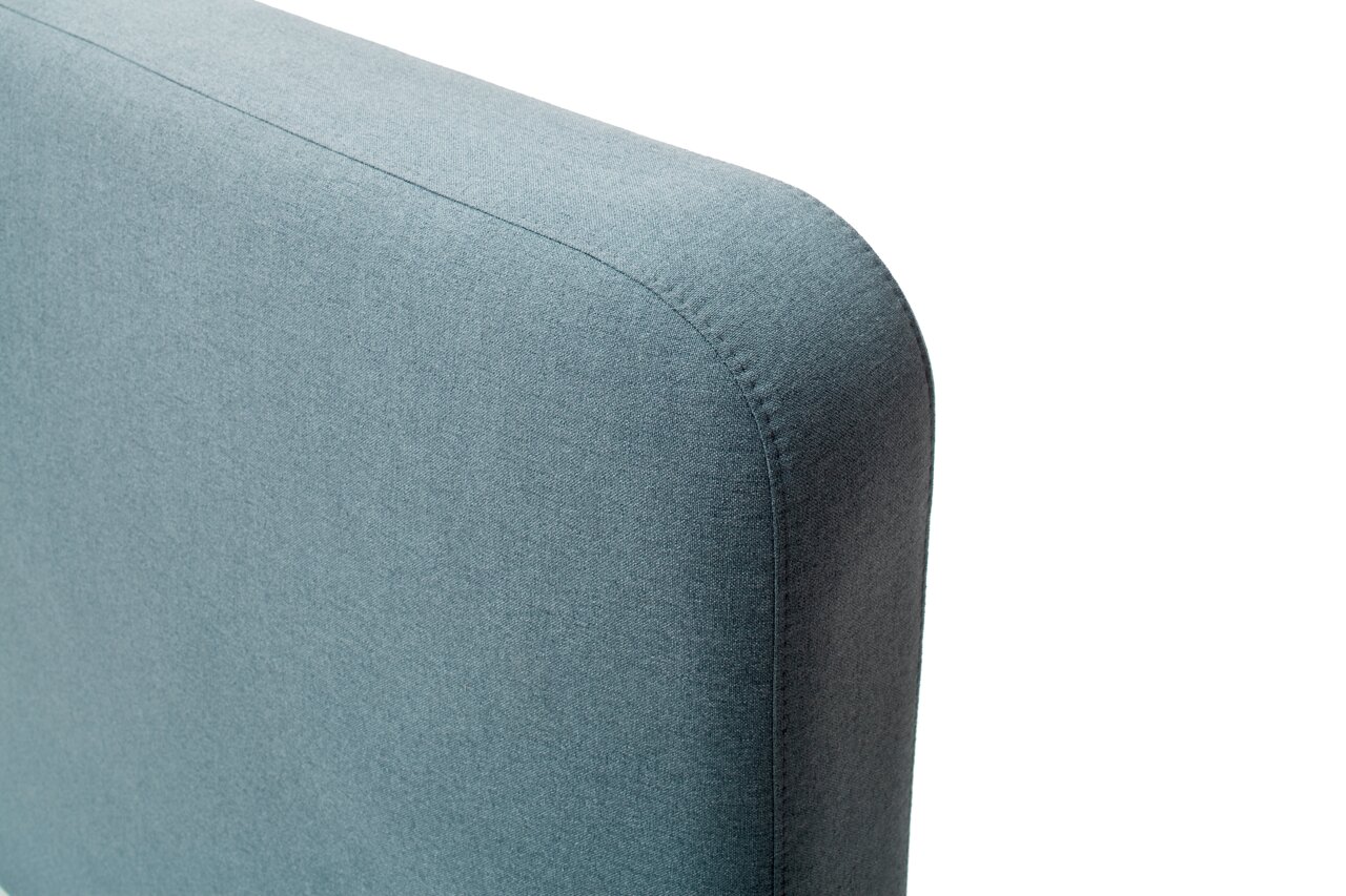 Close-up van een blauw gestoffeerd bed, gezien vanaf de zijkant