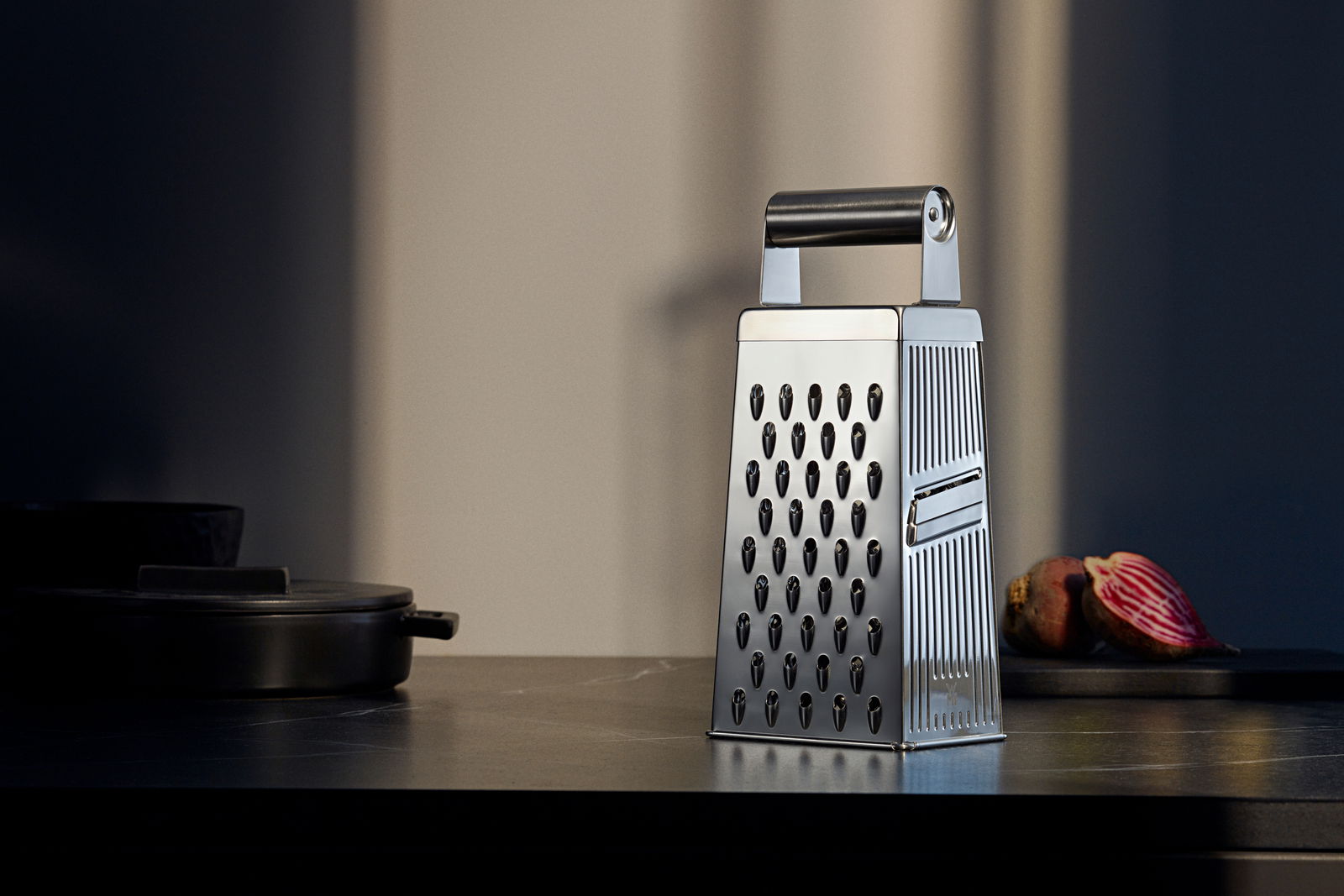 WMF Vierkantreibe Vierkantreibe aus Edelstahl mit schwarzem Griff, seitliche Perspektive, auf einer Küchenarbeitsplatte platziert.