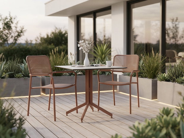 Moderner Balkon mit Tisch und zwei Stühlen, bepflanzte Umgebung und stimmungsvolle Abendbeleuchtung