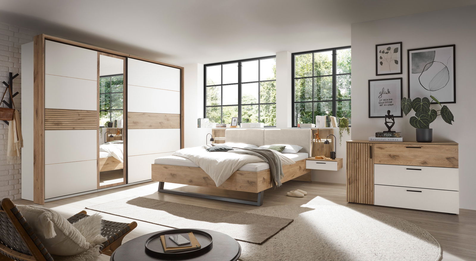 Modernes Schlafzimmer mit Schwebetürenschrank, Bettanlage und Kommode in Holz- und Weißtönen, seitliche Perspektive