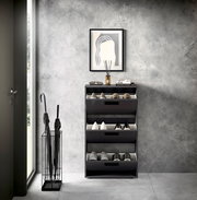 Moderner Schuhkipper mit drei Klappen in einem eleganten Raum, frontal betrachtet.