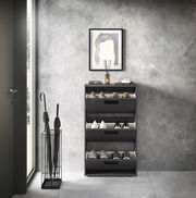 Moderner Schuhkipper mit drei Klappen in einem eleganten Raum, frontal betrachtet.