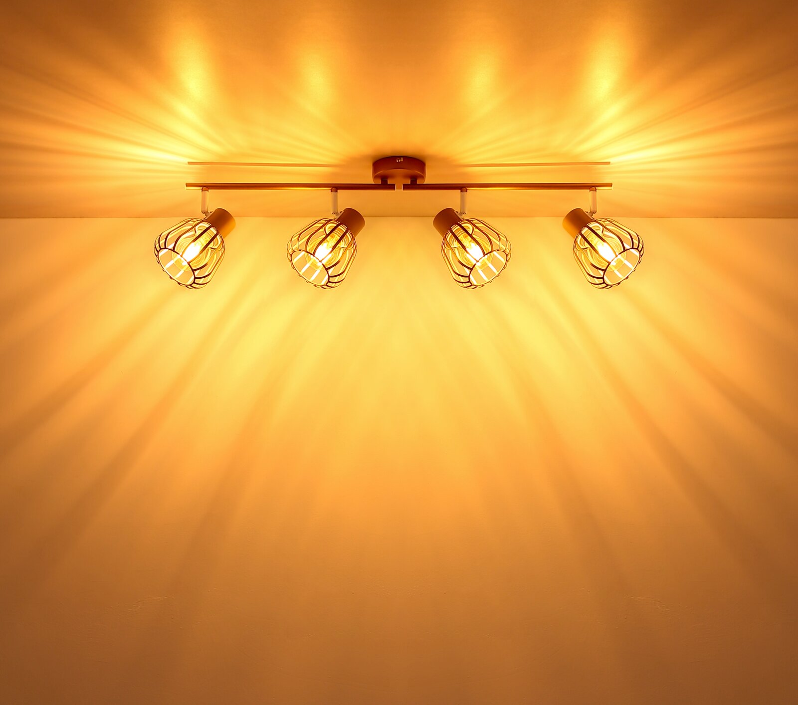 Vierflammige Deckenleuchte im Industrial-Stil mit Drahtgitter-Schirmen und warmem Licht, fotografiert von unten in leichtem Winkel zur Decke