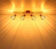 Vierflammige Deckenleuchte im Industrial-Stil mit Drahtgitter-Schirmen und warmem Licht, fotografiert von unten in leichtem Winkel zur Decke