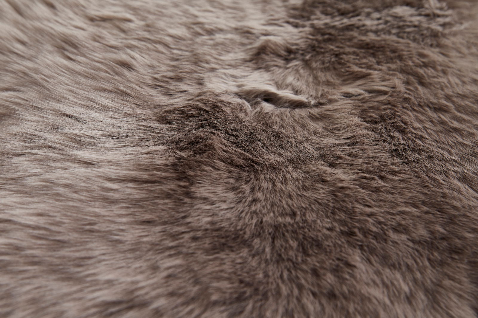 Nahaufnahme eines weichen, braunen Schaffells mit flauschiger Textur.