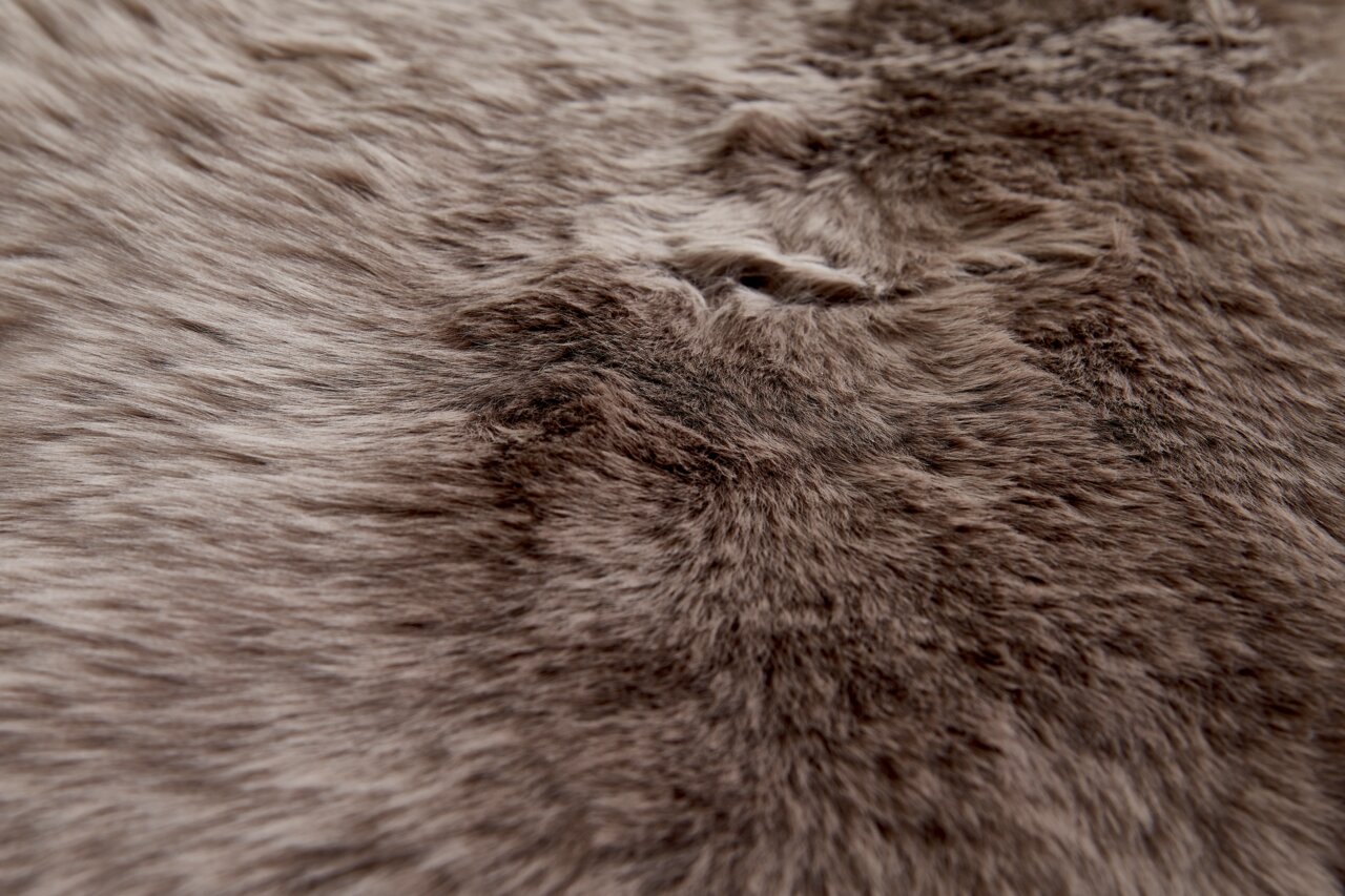 Close-up van een zachte, bruine schapenvacht met een donzige textuur.