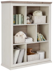 Weißes Regal mit mehreren Fächern, gefüllt mit Büchern, Körben, Kuscheltieren und Kissen, seitliche Perspektive