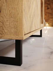 Nahaufnahme eines modernen Möbelstücks mit Holzmaserung und schwarzem Metallgestell, seitliche Perspektive.