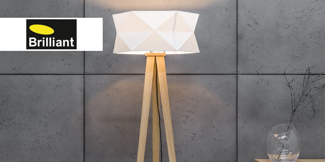 Eine moderne Stehleuchte mit einem weißen Schirm und einem Stativfuß aus Holz. Logo Brillant Leuchten