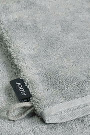 Grauer Waschhandschuh aus Frottee mit schwarzem Joop-Label, Nahaufnahme