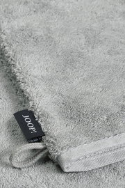 Grauer Waschhandschuh aus Frottee mit schwarzem Joop-Label, Nahaufnahme