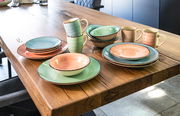 Kombiservice 16-tlg. in Pastellfarben auf einem Holztisch, seitliche Perspektive