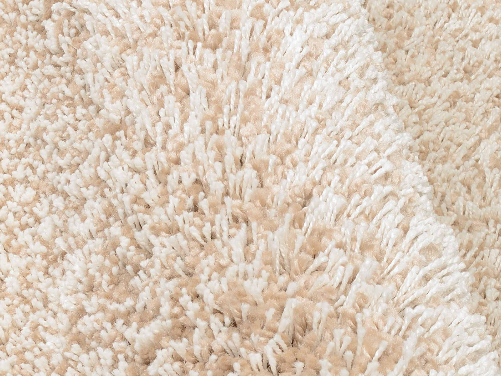 Nahaufnahme eines beigen Hochflor-Teppichs mit weicher, flauschiger Textur.