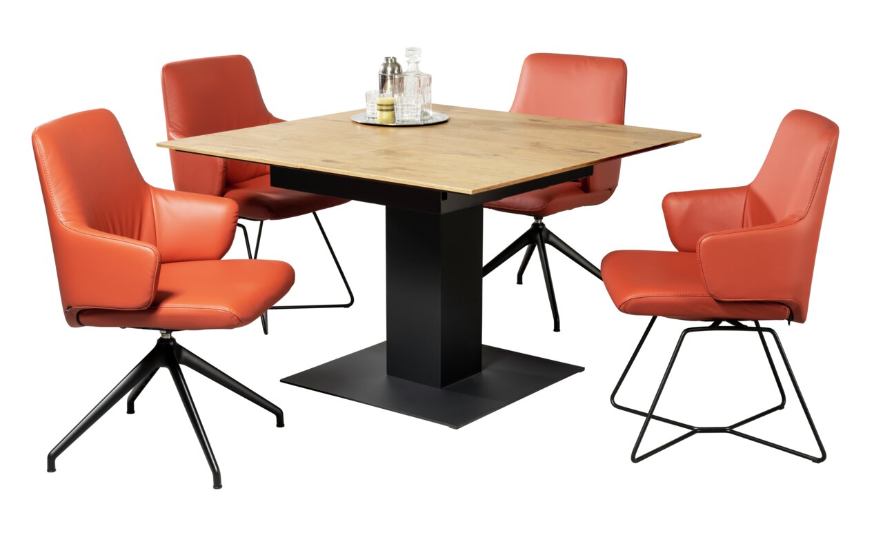 Vier oranje fauteuils rond een vierkante houten tafel met een zwart metalen onderstel, gezien vanaf de zijkant.