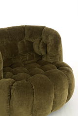 Grüner, gepolsterter Sessel mit weicher, runder Form, Nahaufnahme von der Seite.