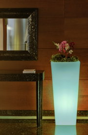 Hoher, leuchtender Blumentopf Melisa 50 mit Orchideen und Grünpflanzen, seitliche Perspektive.