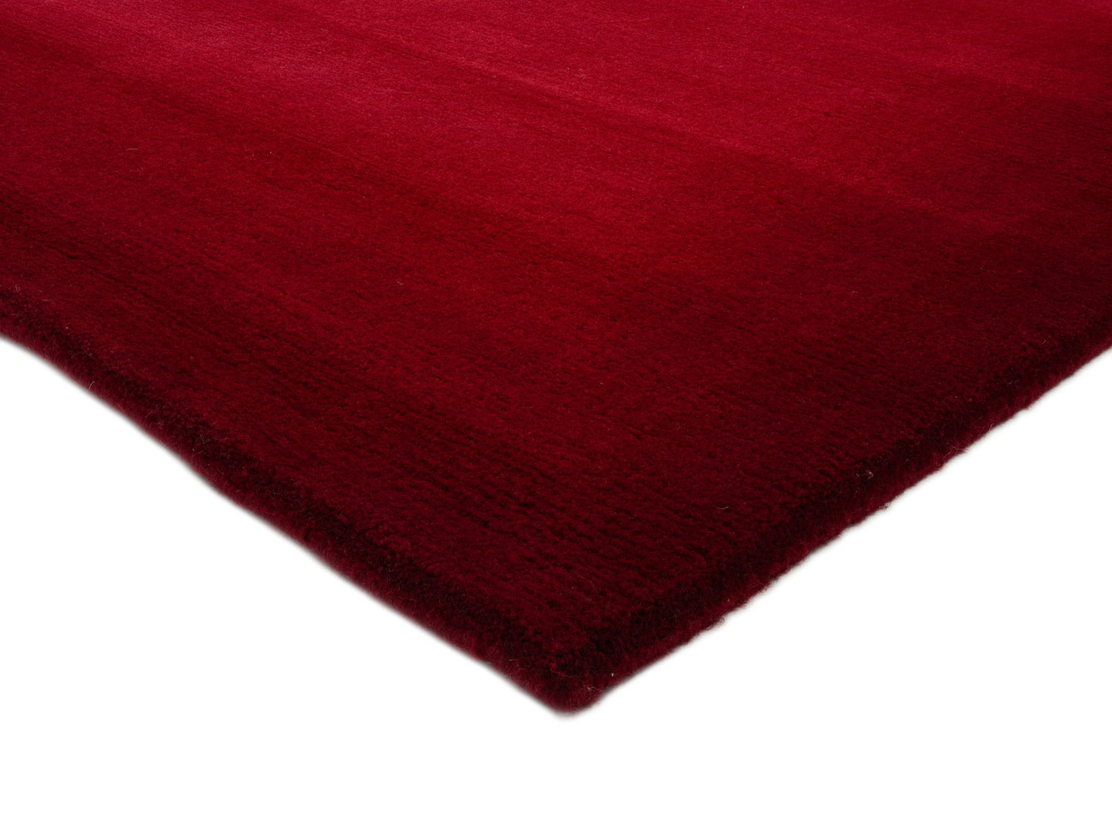 Roter Wollteppich in Nahaufnahme, perspektivisch von der Ecke aufgenommen
