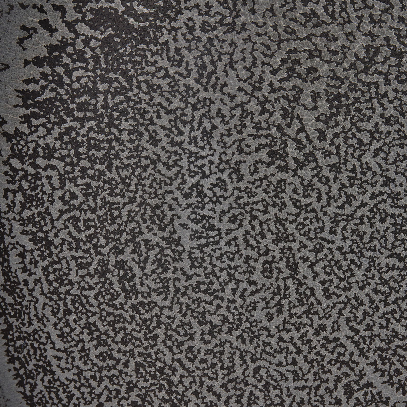 Nahaufnahme einer Oberfläche mit schwarzem und grauem, gesprenkeltem Muster.