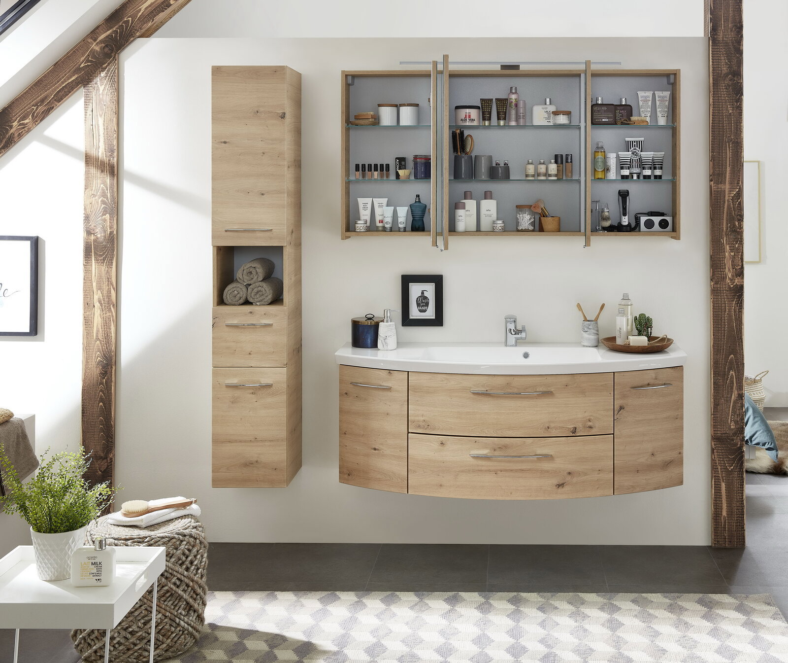 Moderne Badkombination in Holzoptik, bestehend aus einem Waschtisch mit Schubladen, einem hohen Schrank und einem Hängeschrank mit Regalen, frontal abgebildet.