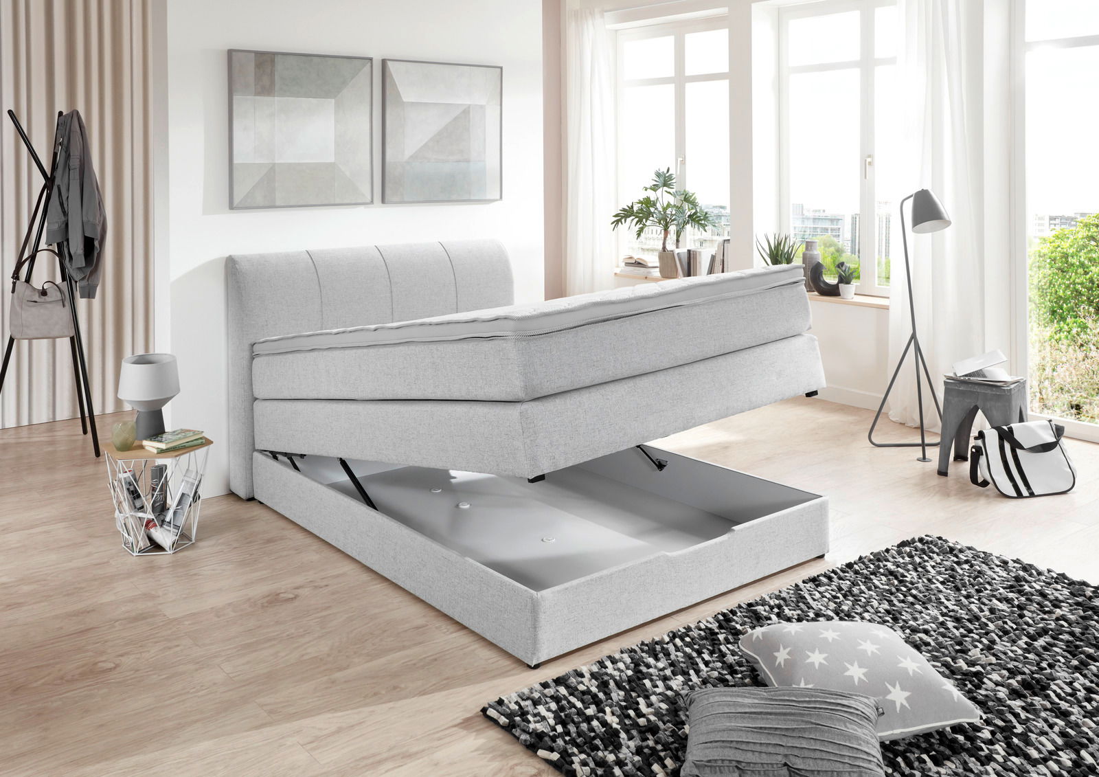 Boxspringbett in hellem Raum mit Stauraumfunktion, seitliche Perspektive