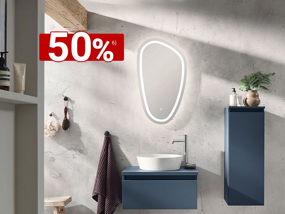 Modernes Badezimmer mit blauem Waschtisch, beleuchtetem Spiegel und 50 % Rabatt-Hinweis in rotem Banner