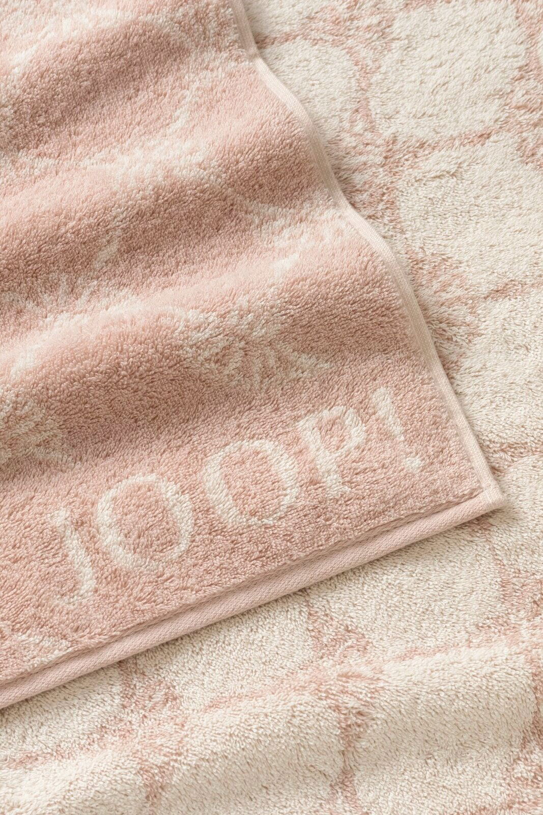 Nahaufnahme eines weichen, rosa Gästetuchs mit eingewebtem Muster und dem Schriftzug 'JOOP!' in der Ecke.