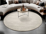 Runder Wollteppich in einem modernen Wohnzimmer, umgeben von einem geschwungenen Sofa und einem runden Couchtisch. Perspektive von oben.