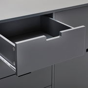 Nahaufnahme eines grauen Sideboards mit geöffneter Schublade, seitliche Perspektive