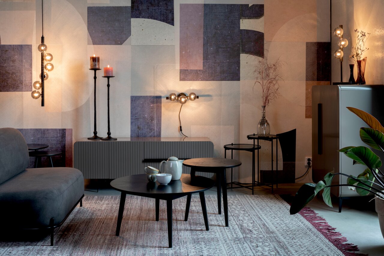 Een moderne woonkamer met stijlvolle tafel- en wandlampen die een warm licht verspreiden. Aanzicht van voren.