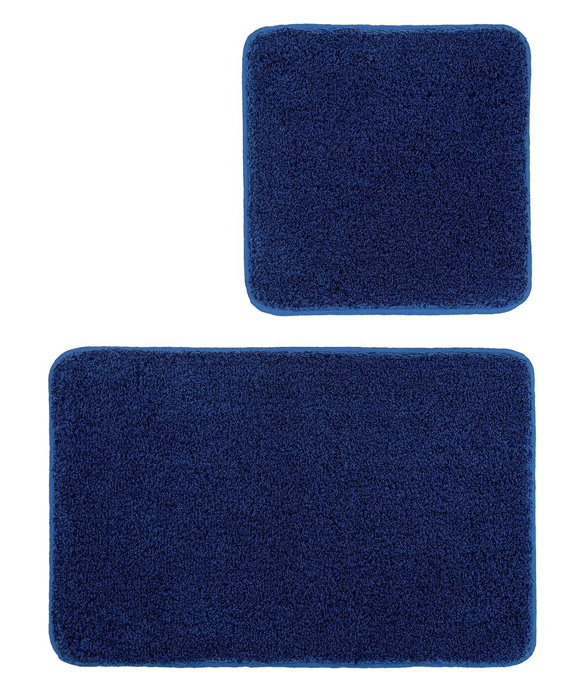 Zweiteiliges Badteppich-Set in Dunkelblau, bestehend aus einem rechteckigen und einem quadratischen Teppich, aus der Vogelperspektive fotografiert.