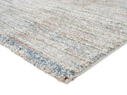 Frisé-Teppich in Nahaufnahme, mit buntem, meliertem Muster und weicher Textur, von der Seite fotografiert.