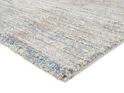 Frisé-Teppich in Nahaufnahme, mit buntem, meliertem Muster und weicher Textur, von der Seite fotografiert.