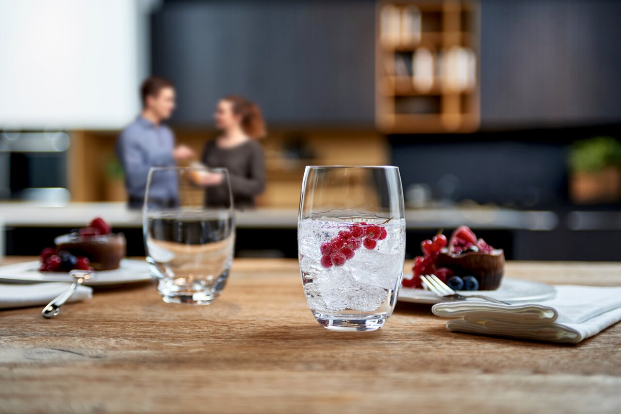 Leonardo Trinkglas CHEERS Trinkglas Cheers 460ml mit Eiswürfeln und roten Beeren, auf einem Holztisch in einer modernen Küche, seitliche Perspektive.