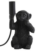 Schwarze Tischleuchte in Form eines sitzenden Affen, der eine Lampenfassung in der Hand hält. Frontalansicht.