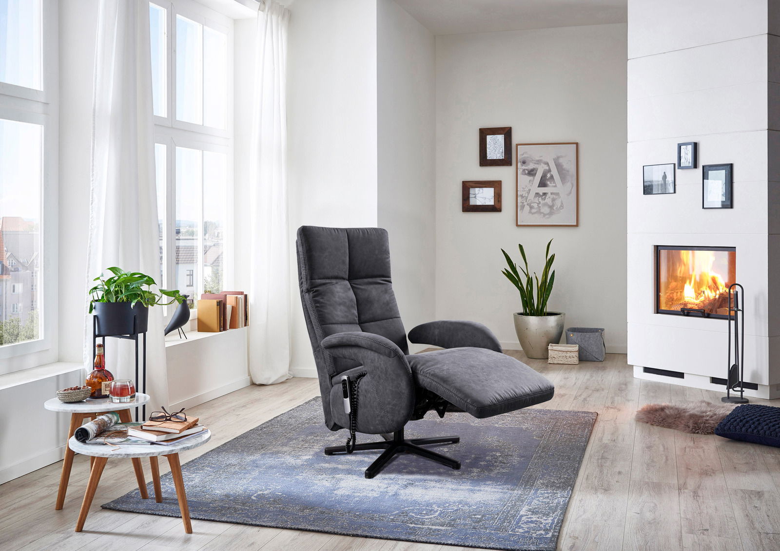 Grauer Sessel in einem modernen Wohnzimmer mit Kamin, von der Seite betrachtet.