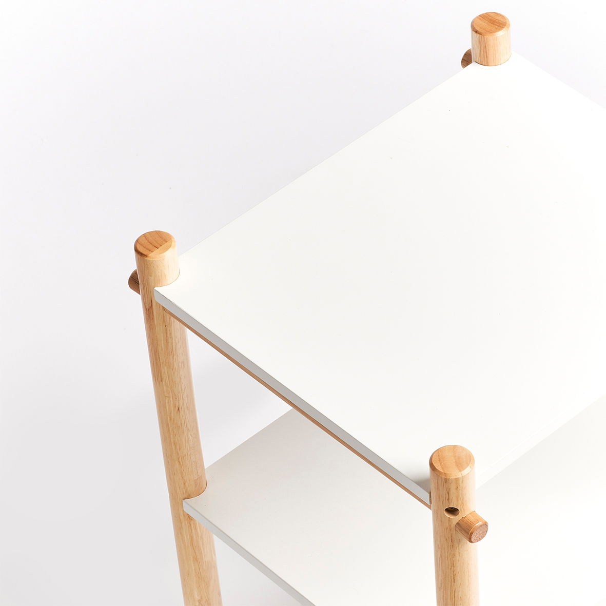 Weißes Kinder-Regal mit Holzbeinen, aus der Vogelperspektive fotografiert.