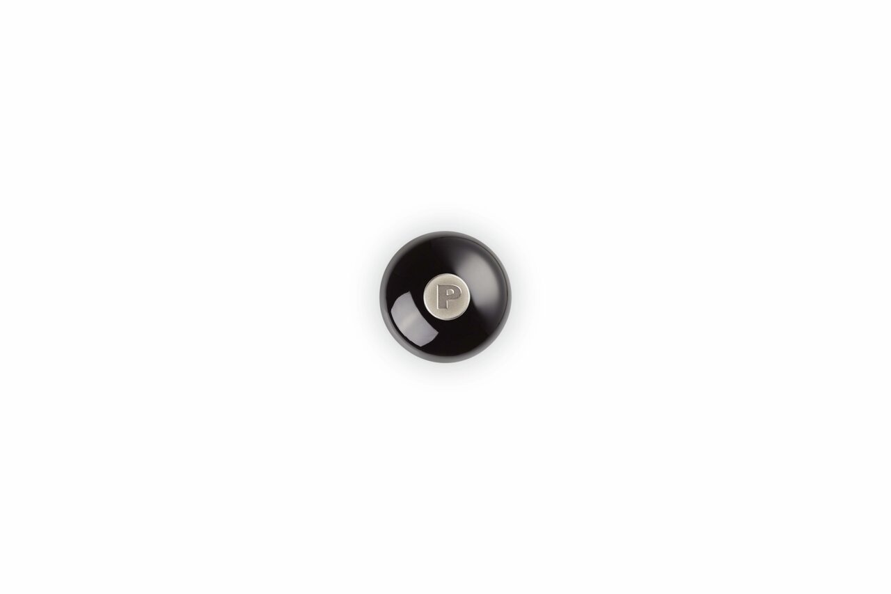 Ansicht von oben auf eine glänzende schwarze Pfeffermühle mit einem silbernen Knopf in der Mitte, der mit einem 'P' gekennzeichnet ist.
