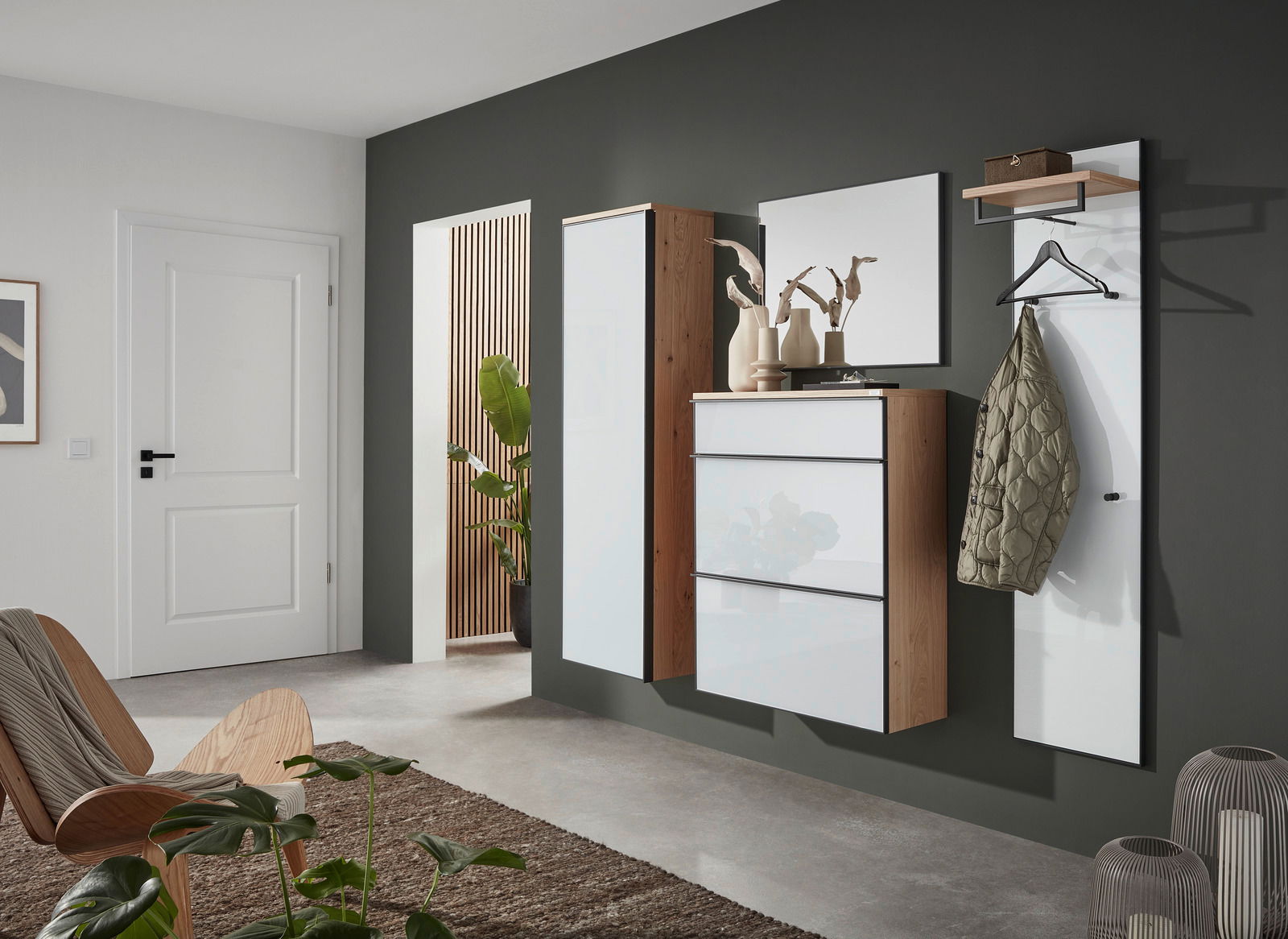 Modernes Garderoben-Set mit vier Teilen, bestehend aus einem hohen Schrank, einem Spiegel, einer Kommode und einer Wandgarderobe mit Haken und Ablage. Perspektive von schräg vorne.