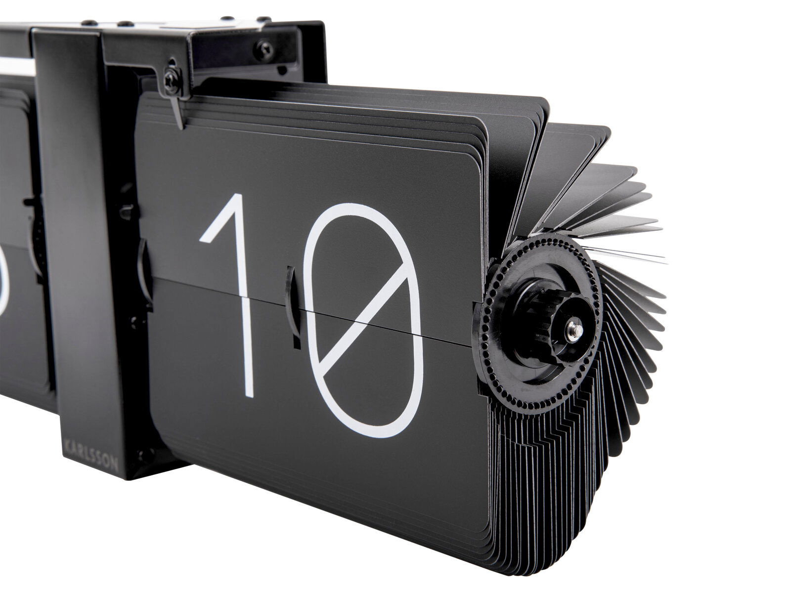 Nahaufnahme einer modernen, schwarzen Wanduhr ohne Gehäuse mit Flip-Mechanismus, die die Zahl 10 anzeigt. Perspektive von der Seite.