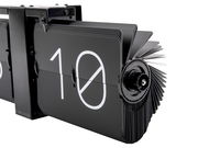 Nahaufnahme einer modernen, schwarzen Wanduhr ohne Gehäuse mit Flip-Mechanismus, die die Zahl 10 anzeigt. Perspektive von der Seite.