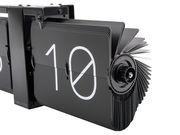 Nahaufnahme einer modernen, schwarzen Wanduhr ohne Gehäuse mit Flip-Mechanismus, die die Zahl 10 anzeigt. Perspektive von der Seite.