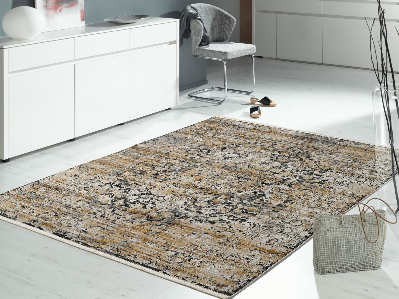 Designer Teppich in einem modernen Wohnzimmer, aus der Perspektive von schräg oben fotografiert, mit einem eleganten, gemusterten Design in Beige- und Grautönen.