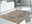 Designer Teppich in einem modernen Wohnzimmer, aus der Perspektive von schräg oben fotografiert, mit einem eleganten, gemusterten Design in Beige- und Grautönen.